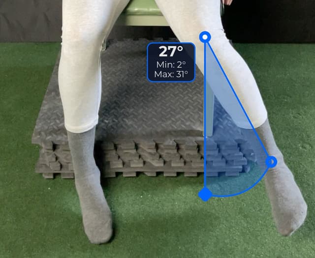 Front view of patient, sitting on a table, demonstrating the internal rotation/external rotation movement. Visual overlay shows a 27 degree angle measurement.